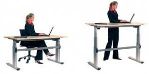 a woman sitting at a desk next to a women standing at a desk