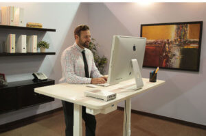 man working in office at a standing desk