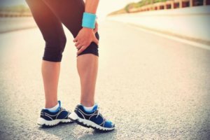 image: female runner holding calf