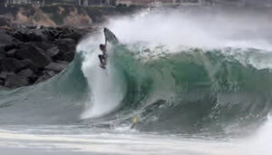 image: surfer falling off board on top of a wave