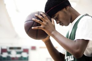 image of a basketball player holding ball to head