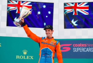 supercars driver nick percat holding up a winners trophy on the podium