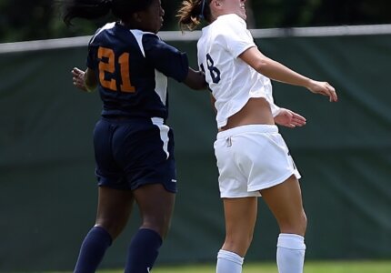 two soccer players heading ball