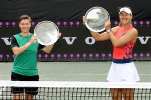 demi schuurs and nicole melichar-martinez holding up trophies